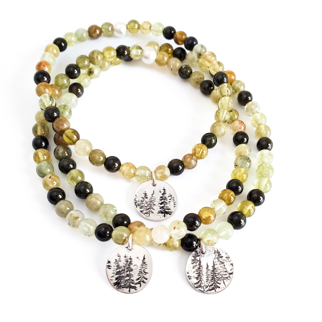Three beaded gemstone bracelets with silver tree-charm pendants, in green and amber tones